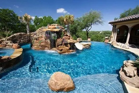 Custom luxury pool with stone waterfall, attached spa, and rockwork — McKinney, TX